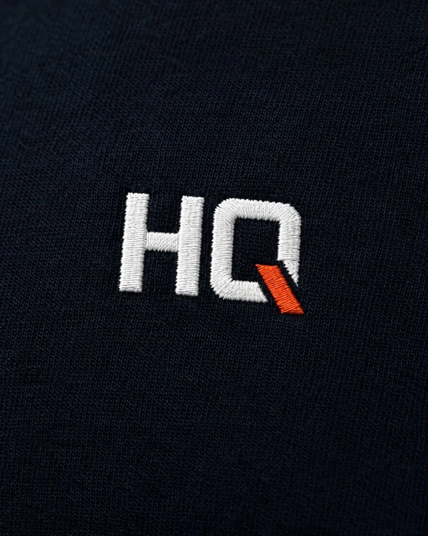 Close-up of the embroidered HQ monogram on cotton jersey